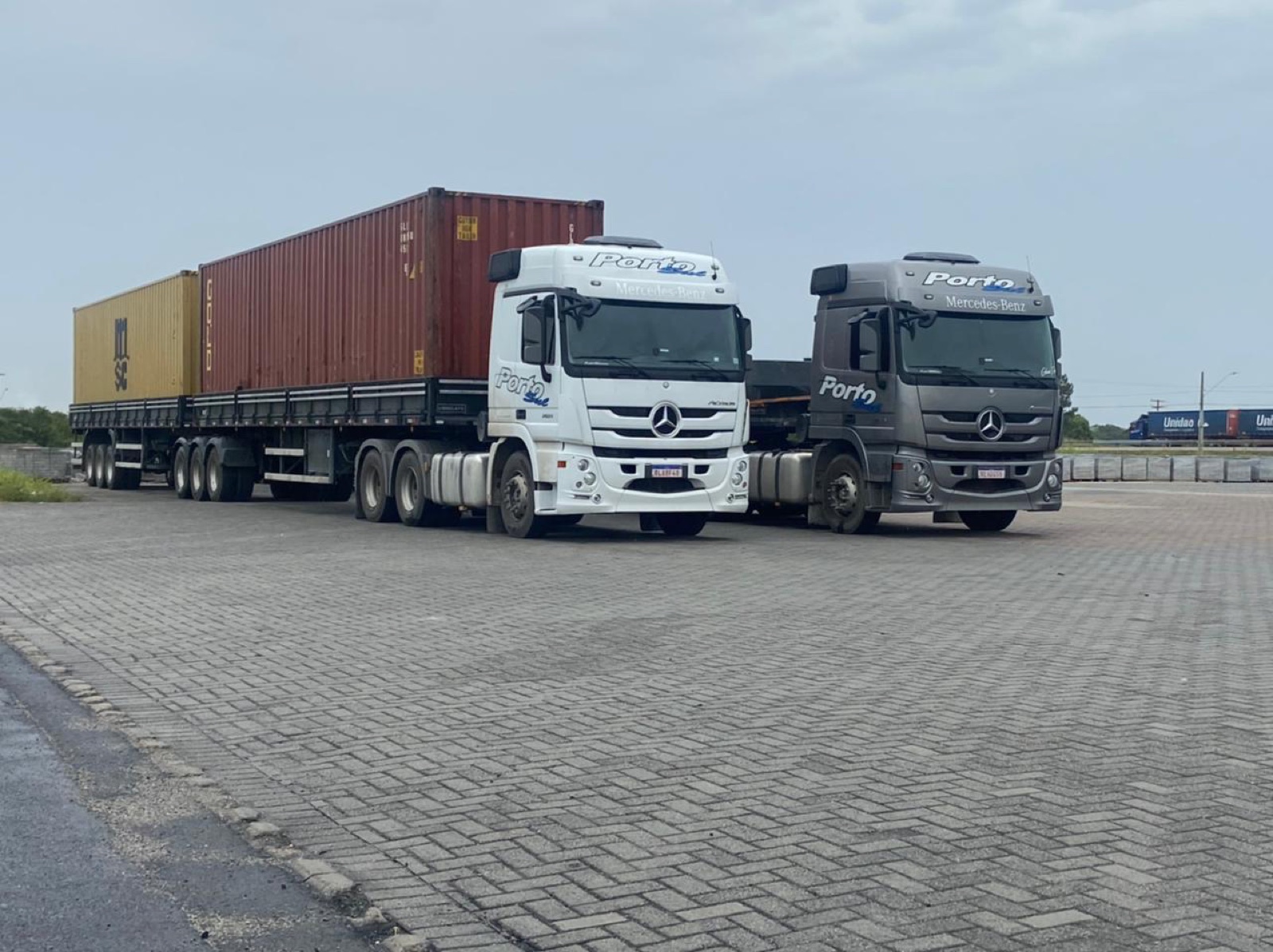 Caminhões da Porto Sul com container marítimo no porto